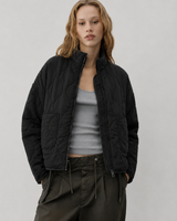 Detail shot of oversized patch pocket on quilted jacket front