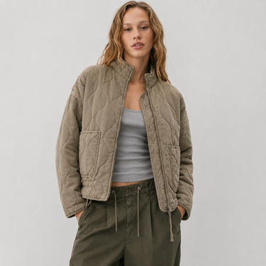 Full-length view of quilted jacket worn over a knit jumper