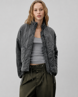 Front view of quilted puffer jacket with high stand collar and patch pockets