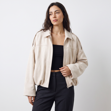 Full-length shot of a model wearing an oversized faux suede bomber jacket
