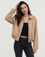Model wearing a faux suede bomber jacket styled with straight-leg trousers