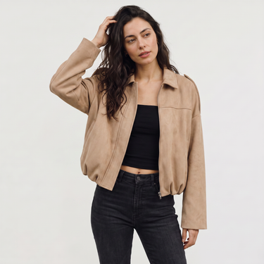 Model wearing a faux suede bomber jacket styled with straight-leg trousers