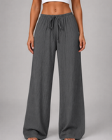 Three-quarter view of wide leg trousers in motion