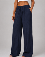 Model wearing wide leg crinkle trousers, front-facing