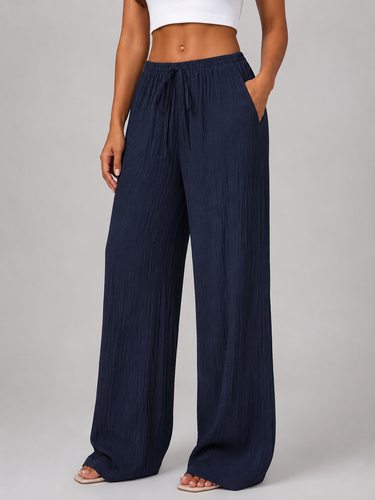 Model wearing wide leg crinkle trousers, front-facing