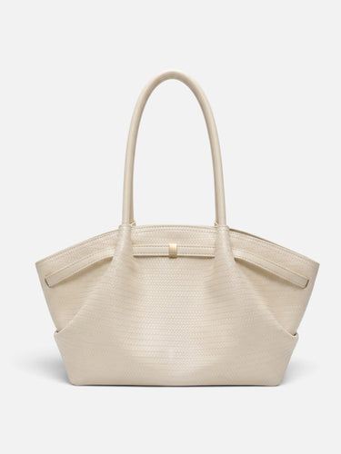 Side view showing the trapeze silhouette and flat base of the woven tote bag