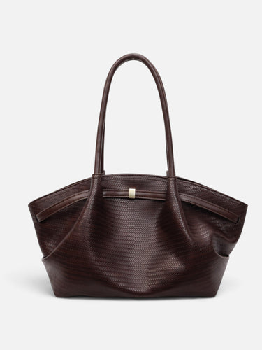 Detail shot of the gold-tone magnetic clasp closure on the tote bag