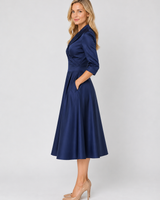 Side view showing the pleated A-line skirt and three-quarter sleeve length