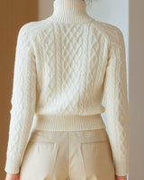 Close-up of raised cable knit texture and zip fastening detail